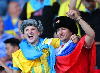 Фото дня. Двое мужчин с флагами России и Украины на матче плей-офф Евро